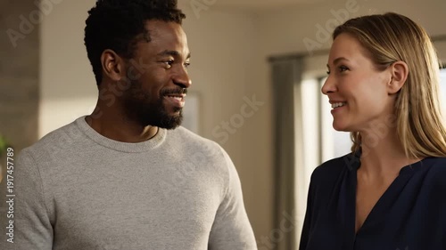 Wallpaper Mural A cheerful multiethnic couple enjoys a lively conversation in their contemporary home. They share smiles and laughter, embodying happiness and connection. Torontodigital.ca