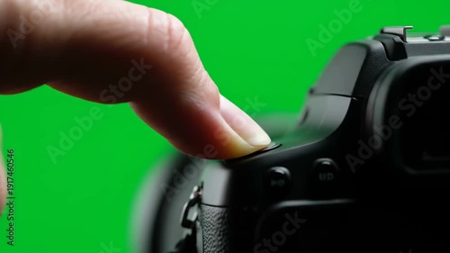 Wallpaper Mural A detailed shot of a human finger activating the camera's shutter button, isolated on a vibrant green screen. Torontodigital.ca