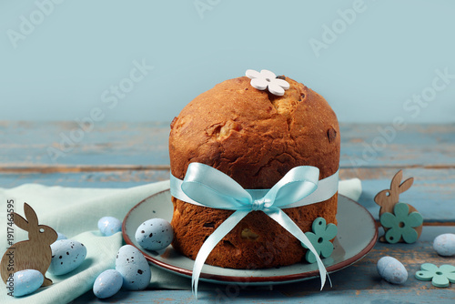 Bild auf Leinwand Plate with delicious Easter cake, painted eggs and bunnies on blue wooden table