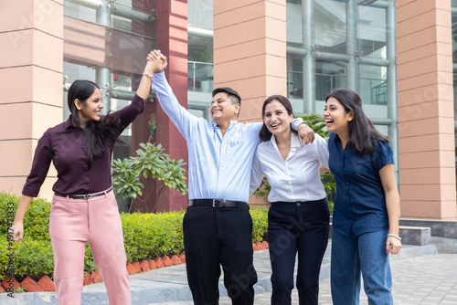 Happy young indian entrepreneur, office employees having fun in break time outdoors, Teamwork and unity, Business and finance.