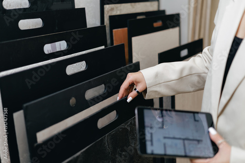 Bilde på lerret Woman interior designer selecting materials in showroom with digital tablet