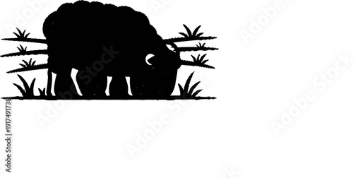 Black silhouette of a sheep grazing in a grassy field