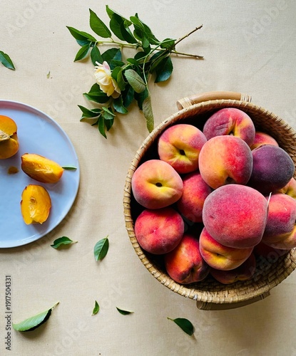 Photography Elegant top view of ripe peaches in a woven basket with sliced fruit and yellow flowers for high-end culinary lifestyle advertisements