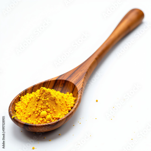 Wooden spoon filled with turmeric powder on a white background