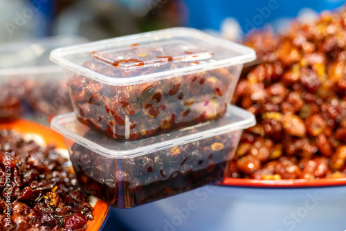 Candied Jujube dates packed in a clear plastic box, Sweetened Jujube, Dried Jujube in Syrup, showing glossy red-brown texture. Ideal for product, dessert, Asian food, and packaging concepts