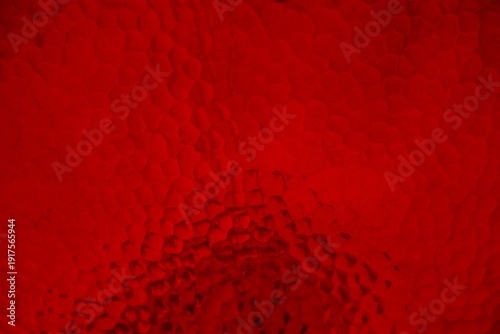 Red hammered metallic surface with texture and irregular pattern for background and wallpaper, bright tone