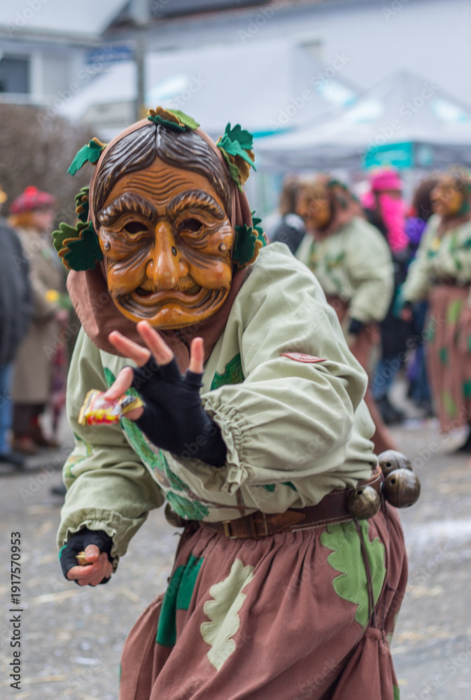 Naklejka premium Traditional costumes of old woman (witch) with wooden mask during the Swabian-Alemannic carnival (