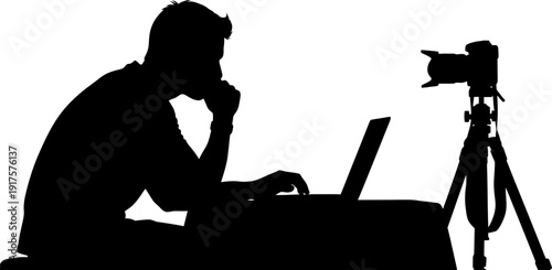 Photographer editing photos on a laptop with camera