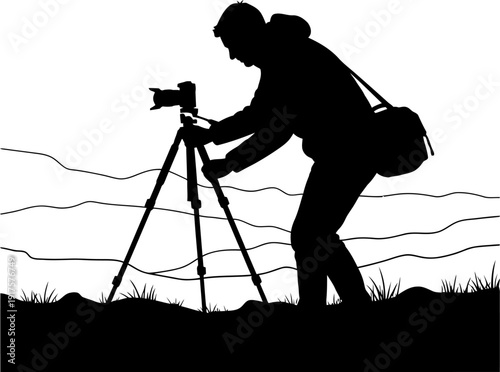 Silhouette of a nature photographer adjusting a camera on a tripod