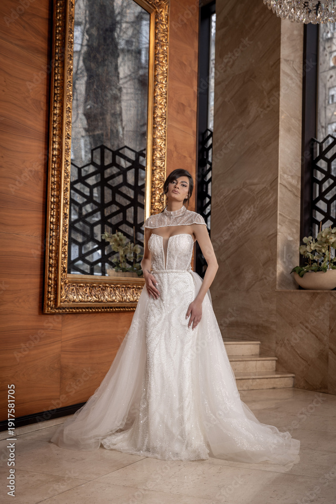 Fototapeta premium Young bride posing in classic wedding dress with veil