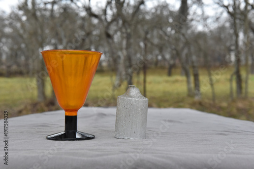 Orange glass stemmed goblet and silver textured candle
