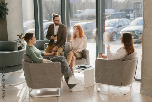Fotografía Business colleagues having informal meeting in modern office lobby