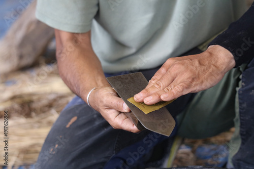 左官コテの手入れをする男性