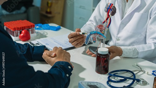 The doctor and patient are discussing prostate examinations, providing advice and explanations to a testicular cancer patient in the examination room, using a model of the male genitalia.