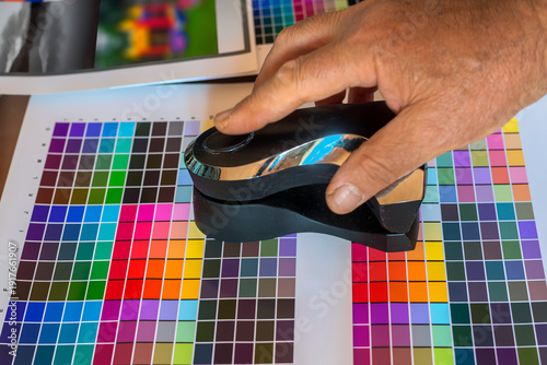 Professional spectrophotometer scanning color chart patches for ICC profile creation and printer color calibration in a photo lab.