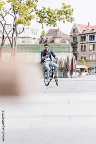 Wallpaper Mural Young man with bicycle in the city using cell phone Torontodigital.ca