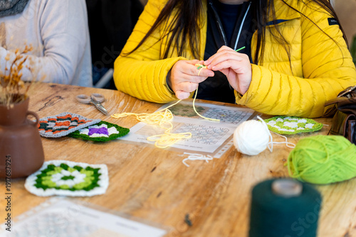 Konstfotografi Person crocheting yarn with hook at craft club