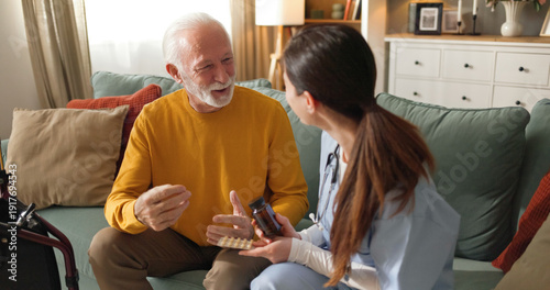 Fotografie A home health nurse talks with a senior man about his medication