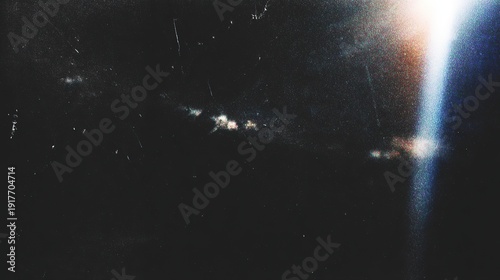 Retro distressed film effect with scratches, dust particles and light leaks. Noisy grain texture with light leak flares on black background.