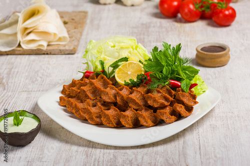 Turkish Cig kofte Plate with Fresh Herbs Lemon and Sauce