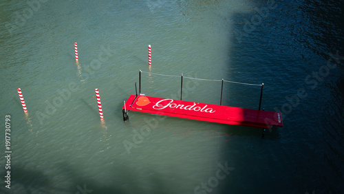 Blick auf eine rote Anlegestelle für Gondeln auf einem Seitenkanal des Gardasees