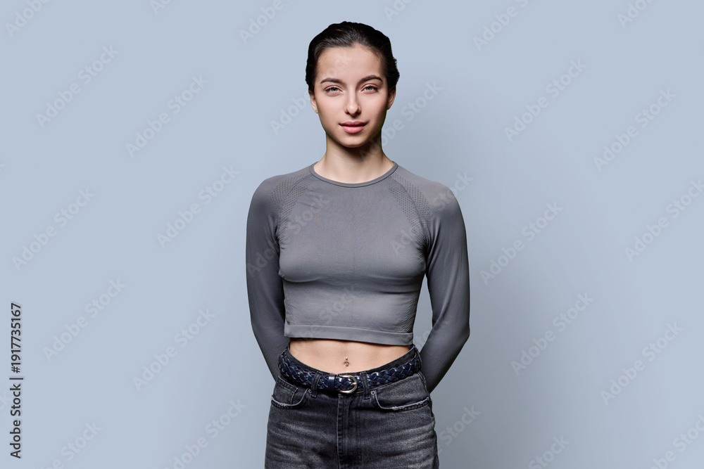 Obraz premium Portrait of beautiful fashionable young woman, 18-19 years old on gray background