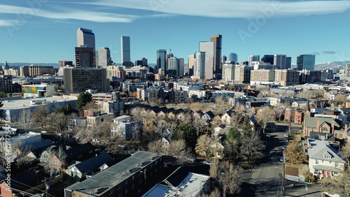Blocks south of City Park West lead toward clustered downtown skylines, glass towers near Broadway. Afternoon light reveals brick patterns, reflective windows, dormant treetops, Denver, Colorado