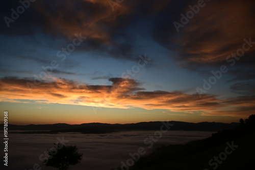 stunning view of a sunrise between fog ans sky