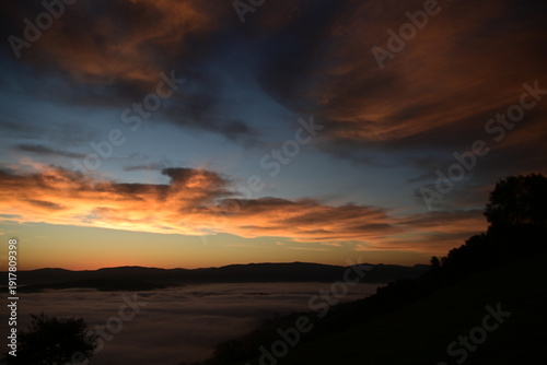 stunning view of a sunrise between fog ans sky