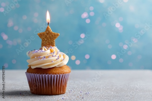 Festive cupcake with star candle and sprinkles against blue bokeh background