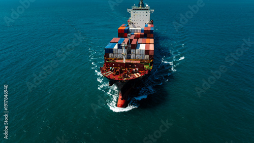 Close up aerial front view of cargo ship cutting through water waves for global business logistics and international import export trade transportation industry.
