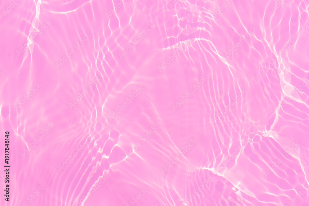 Obraz premium Pink water bubbles on the surface ripples. Defocus blurred transparent pink colored clear calm water surface texture with splash and bubbles. Water waves with shining pattern texture background