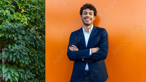 Confident professional smiling against orange wall