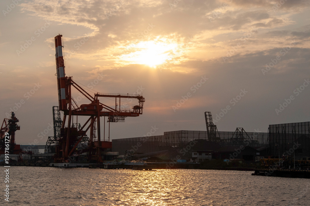 Fototapeta premium Silhouette of Industrial Gantry Crane at Port During Sunset