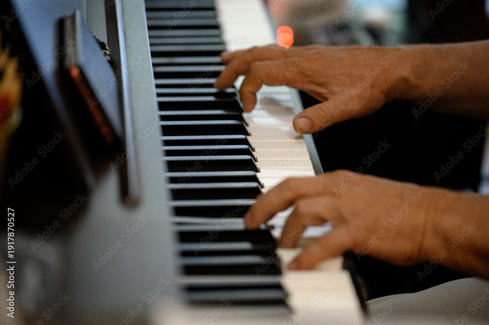 Obraz premium Close-up of male hands playing the keys of a digital piano