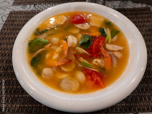 Authentic Thai Tom Yum soup in bowl with fresh herbs and spices