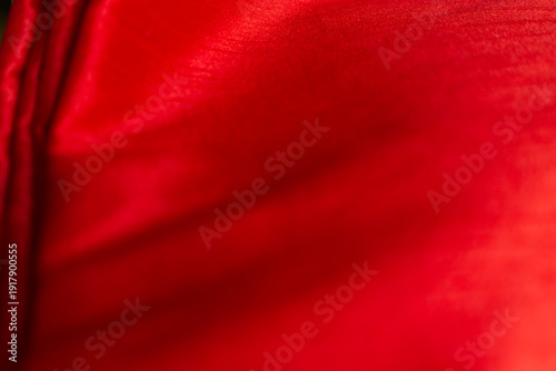 top-view view of bright red satin fabric, forming beautiful waves.