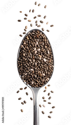 Chia seeds in a metal spoon with scattered dry seeds falling around, healthy superfood ingredient close-up on isolated background
