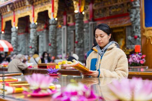 Fényképezés Female worshipper lighting incense stick at temple