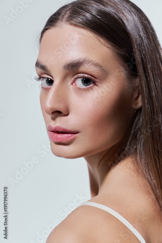 Photography Graceful young woman gazes confidently with radiant beauty against a minimalist