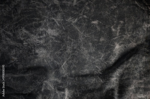 High resolution macro texture of faded dark grey washed denim fabric.