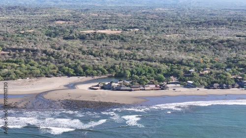 View from above a sandy beach and village near the ocean