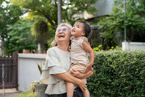 A cheerful grandmother embraces her granddaughter in the home, sharing a special moment. Their bond reflects love, care, and cherished memories, celebrating family joy and the enjoyment of retirement