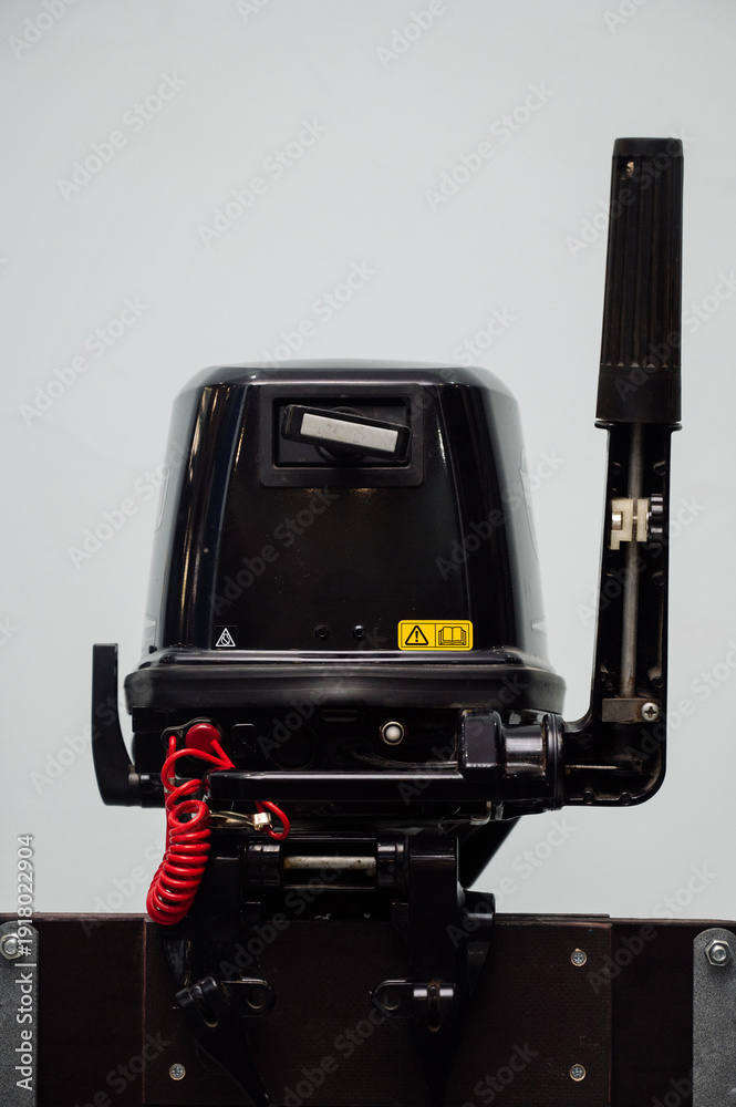 Fototapeta premium Outboard motor in the showroom: close-up of the hull and tiller.