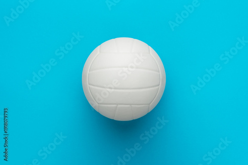 Top view photo of white volleyball ball as volleyball concept . Minimalist flat lay image of leather volleyball ball over blue turquoise background with copy space and central composition.