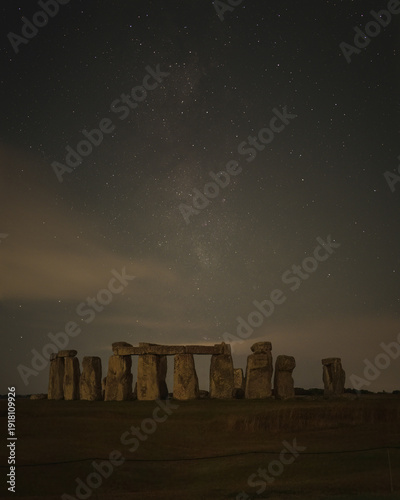 The Milky Way glows above Stonehenge at night, captured under dark skies