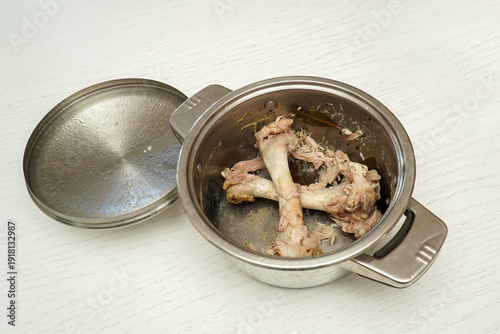 Photos Two bones with the remains of meat from turkey drumsticks lie at the bottom of the pan