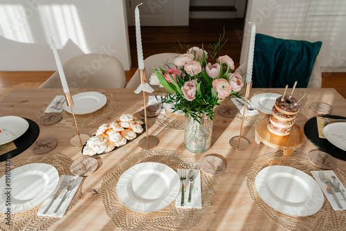 Tableau sur toile Stylish home table decor with floral centerpiece and elegant tableware