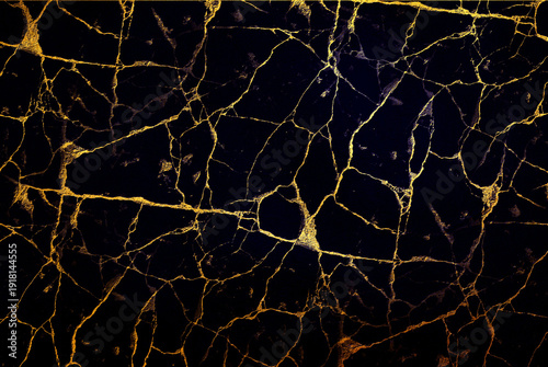 Fotografie A dark blue surface is covered with a network of golden cracks