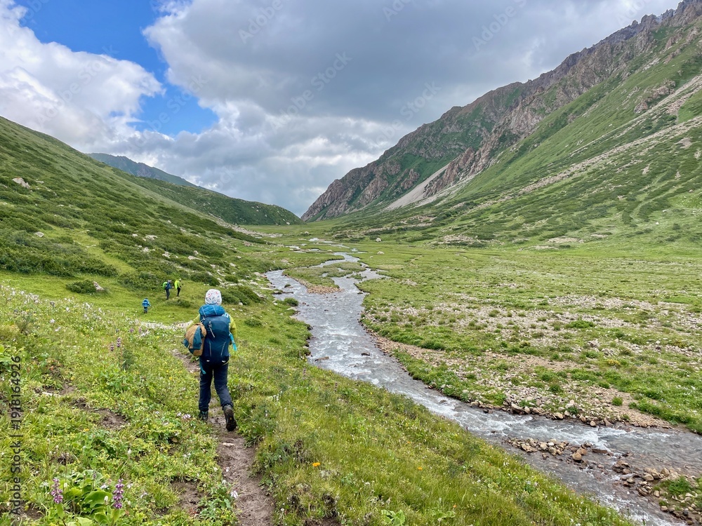 Fototapeta premium Group of hikers undertaking the multi-day Ak-Su Traverse in the spectacular Terim Tor Valley, Kyrgyzstan.